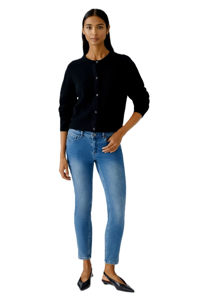 Strickjacke Oui Ilaya in Black. Kuschelig weiche Garnmischung mit glatt gestrickter Oberfläche und markanten Outside Seams. Lässiger, leicht verkürzter Schnitt mit zurückversetzter Schulternaht. Rundhalsausschnitt, lange Ärmel und Knopfleiste mit Knöpfen in Hornoptik.