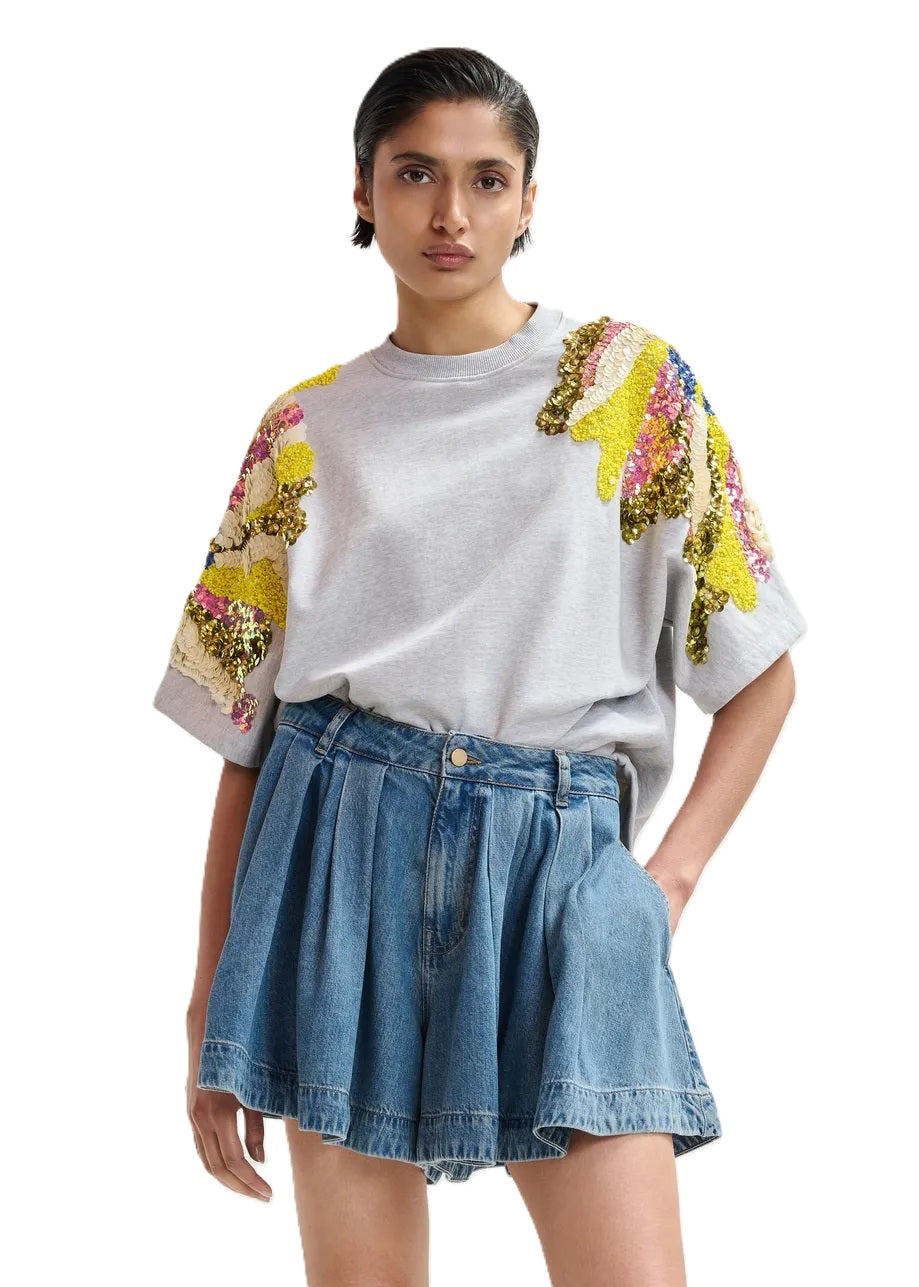 Sweatshirt Essentiel Antwerp JADDA EMBROIDERED SWEATSHIRT. Das Sweatshirt aus reiner Baumwolle ist locker und kastig geschnitten und verfügt über überschnittene Schultern und kurze Ärmel. Es ist mit auffälligen bunten Pailletten- und Perlenverzierungen an den Schultern verziert. Doppelte Nähte verleihen dem Design einen coolen Look. 