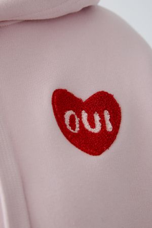 Sweatshirt Oui mit Kapuze. Kastiger, gerader Schnitt mit normaler Länge. Feminine Herzapplikation und weiche, angenehme Materialqualität aus Baumwolle und Polyester.