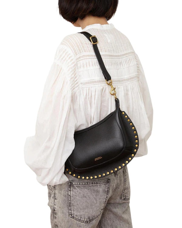 Tasche Isabel Marant OSKAN MOON. Diese elegante Baguette-Schultertasche ist aus genarbtem, pflanzlich gegerbtem Kalbsleder in Schwarz gefertigt. Der abnehmbare und verstellbare Tragriemen ermöglicht vielseitige Trageoptionen. Im Inneren bietet die Tasche zwei Fächer sowie ein mittiges Reißverschlussfach. Goldfarbene Details und das Logo auf der Vorderseite 