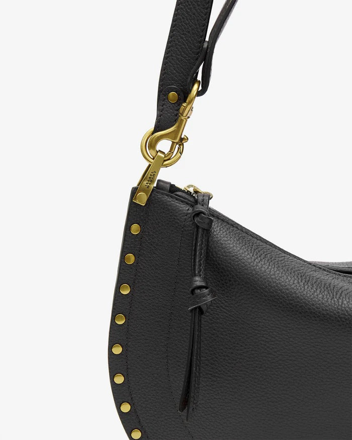 Tasche Isabel Marant Oskan Moon Zip Shoulder Strap in schwarz. Umhängetasche in schwarz aus genarbtem Leder. Man kann die Tasche in der Hand, über der Schulter, oder auch Crossbody tragen. Der Schulterriemen ist verstellbar und hat Nietenknöpfe. Die Tasche hat Ringe aus graviertem Metall. 