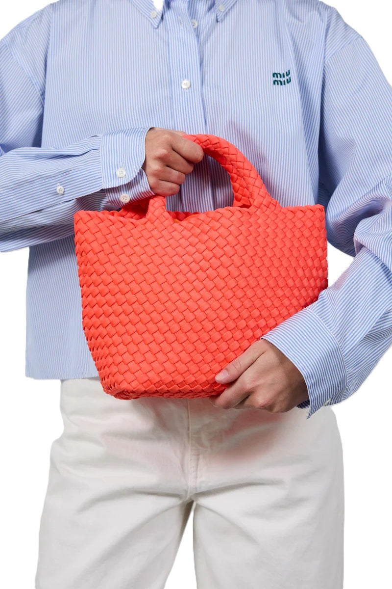 Tasche Marrea Midi Aperitivo Ready. Diese kleine Tasche in orange besticht durch ihre besondere, handgewebte Optik und verbindet lässige Eleganz mit dem modernen Strandlook. Die Größe bietet genügend Raum für alle wichtigen Essentials. Sie hat zwei Top-Griffe zum Tragen.