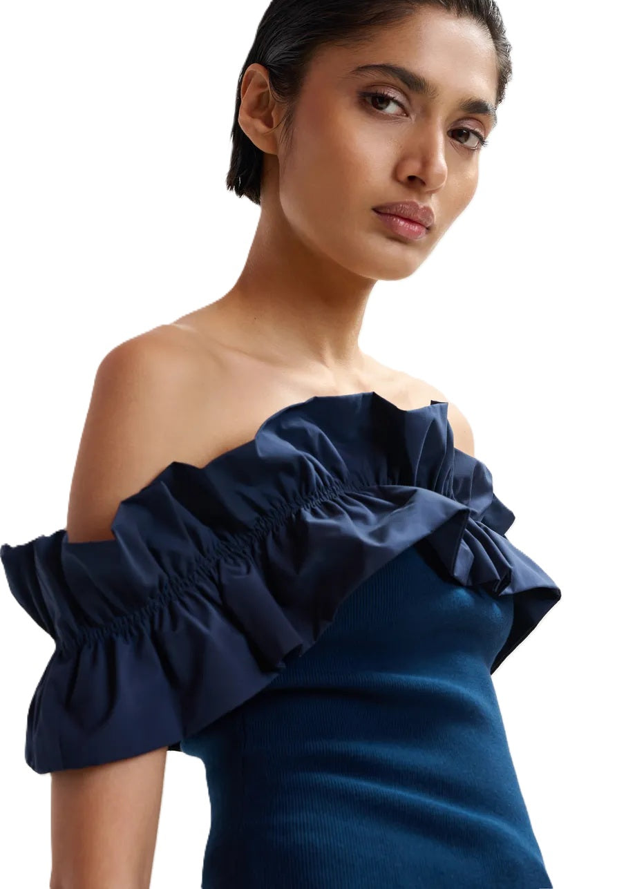 Shirt Essentiel Antwerp JAQUA KNITTED TOP in blau. Das schulterfreie Top liegt eng am Körper an. Der elastische Ausschnitt wird von einer voluminösen Rüsche umrahmt, die sich über die Schultern erstreckt. Die Rippenstrickdetails betonen die figurbetonte Passform.