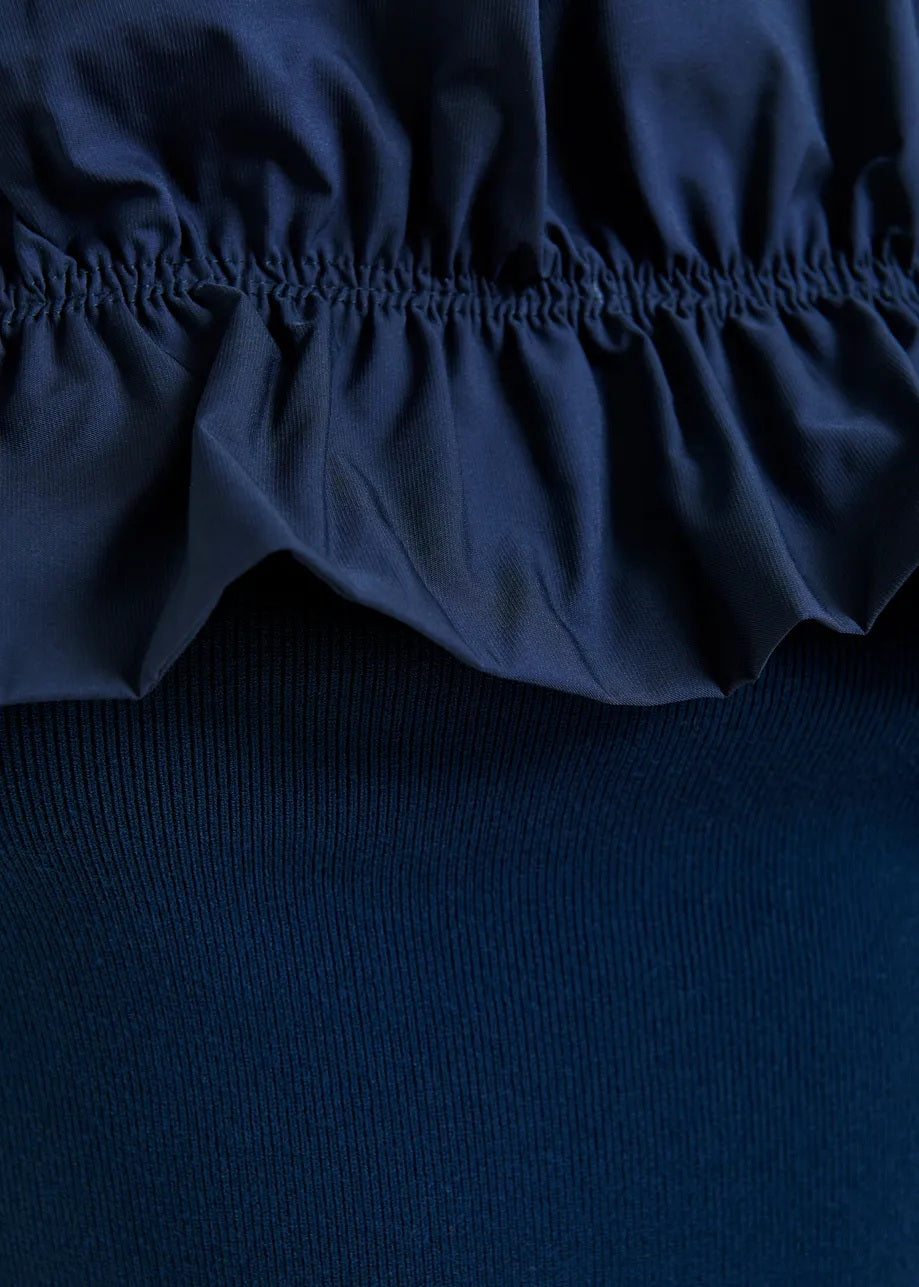 Shirt Essentiel Antwerp JAQUA KNITTED TOP in blau. Das schulterfreie Top liegt eng am Körper an. Der elastische Ausschnitt wird von einer voluminösen Rüsche umrahmt, die sich über die Schultern erstreckt. Die Rippenstrickdetails betonen die figurbetonte Passform.